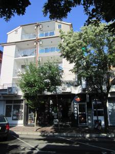 a tall white building on the corner of a street at Central Guesthouse in Nesebar