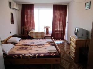 a bedroom with two beds and a television in it at Central Guesthouse in Nesebar