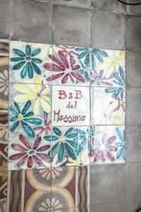 un suelo de baldosa con un cartel con flores en B&B del Massimo, en Palermo