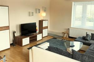 a living room with a couch and a television at Sieben-Berge-Ferienwohnungen in Alfeld