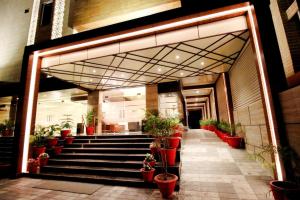 eine Lobby mit Topfpflanzen und Treppen in einem Gebäude in der Unterkunft Pinnacle by Click Hotels, Lucknow in Lucknow