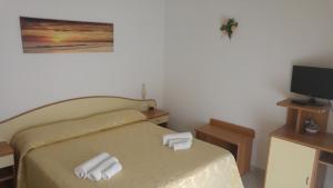 1 dormitorio con 1 cama con 2 toallas en Villa Natalina, en Isquia