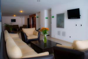 a living room with couches and a vase of flowers at Hotel San José Plaza in Bucaramanga