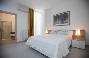 - une chambre blanche avec un lit blanc et une fenêtre dans l'établissement B&B Sapore di Sale con parcheggio ed ombrellone in spiaggia, à Porto Cesareo