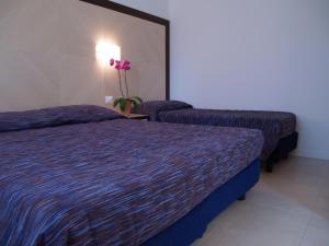 カヴァッリーノ・トレポルティにあるJunior Depandanceの紫のシーツが備わるホテルルームのベッド2台