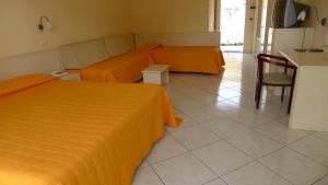 1 dormitorio con 2 camas, mesa y cocina en King's House Hotel Resort, en Mascali