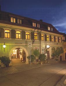 un gran edificio con un arco delante de él en Gasthof Grüner Baum en Dettelbach