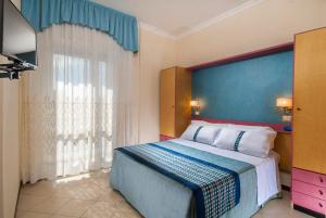 Ένα ή περισσότερα κρεβάτια σε δωμάτιο στο Hotel Helios