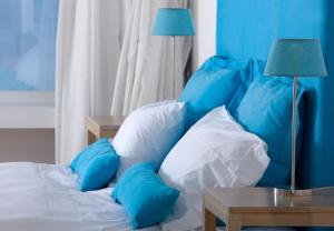 a bed with blue pillows and a table with a lamp at Relais Blu in Massa Lubrense
