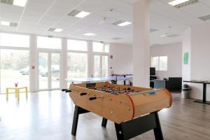 a foosball table in an empty room with a table at Adonis Hauts De Honfleur in Équemauville