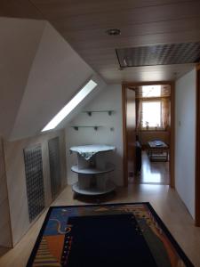 an attic room with a table and a rug at Wohnung Kronacher in Stadtsteinach