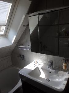 a bathroom with a sink and a mirror and a tub at Wohnung Kronacher in Stadtsteinach
