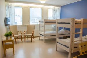 Pokój z 2 łóżkami piętrowymi, stołem i krzesłami w obiekcie Spa Hostel Kunnonpaikka w mieście Kuopio