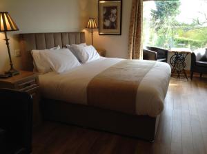 a bedroom with a large bed and a window at Benbulben Farmhouse B&B in Drumcliff