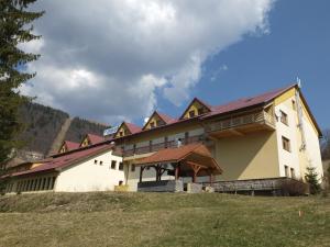 a large building with a roof on a hill at Penzion Zornicka in Donovaly