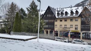 una calle cubierta de nieve frente a un edificio en Apartament Araneu, en Vielha