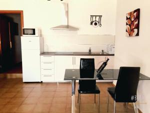 a kitchen with a table and black chairs at Vivienda vacacional Finca Ribera De Cortes in Nazaret
