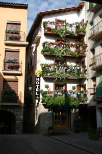een hoog gebouw met balkons en planten erop bij Hotel Can Mestre in El Pont de Suert