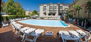 ベッラーリア・イジェア・マリーナにあるHotel St. Moritzの白い椅子とたくさんの家具が備わるプール