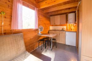 a kitchen with a table and chairs in a cabin at Atrium - Domki Letniskowe in Krynica Morska