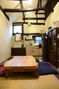 a kitchen with a wooden table in a room at Guest House KuKu in Niigata