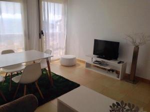 sala de estar con TV, mesa y sillas en Apartment Roxana, en Benidorm