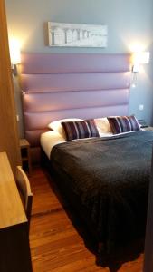 a bedroom with a bed with a purple wall at Hotel Napoléon in Cherbourg en Cotentin