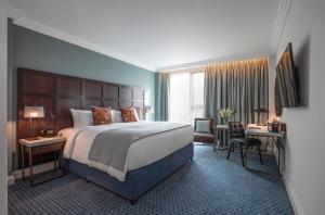 劍橋的住宿－Clayton Hotel Cambridge，酒店客房设有一张大床和一张书桌。
