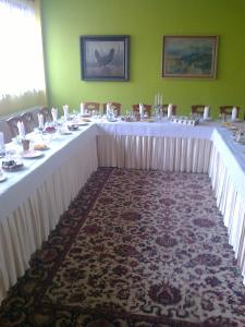 una mesa larga con mesas blancas y sillas en una habitación en Penzión Váh, en Liptovská Teplička