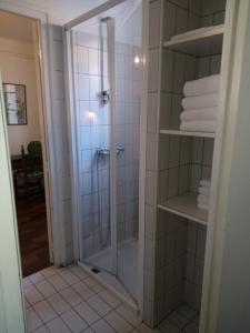 a shower with a glass door in a bathroom at Hôtel des Templiers in Collioure