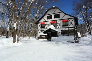 una casa en blanco y negro en la nieve en Hakuba Skala Inn en Hakuba