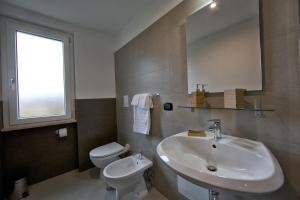a bathroom with a sink and a toilet and a mirror at lepini suites affittacamere in Patrica