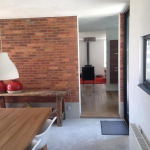 a room with a brick wall and a wooden table at Dijkhuis Breskens in Breskens