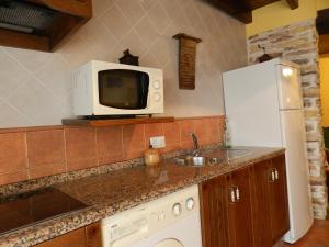 cocina con fregadero y microondas en Alojamiento Rural La Rabida 25, en Cumbres Mayores