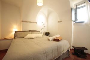 a bedroom with a large white bed with a window at Blu Oltremare in Borgio Verezzi