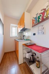 a small kitchen with a red counter and a sink at Lucca in Villa San Marco in Lucca