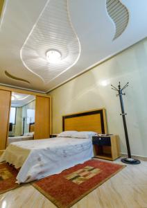 ein Schlafzimmer mit einem Bett mit einem Kreuz an der Decke in der Unterkunft Umbrella Holidays l 1Bd room l in Dcheïra