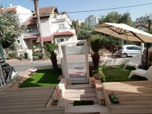 a stairway with an umbrella and a lawn at Quiet Garden in Rishon LeẔiyyon +10 photos