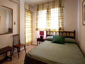 um quarto com uma cama, uma cadeira e uma janela em Hotel Costa em Mazarrón