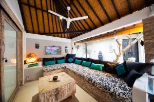 a living room with a large couch and a ceiling at La Bella Vita Residence in Seminyak