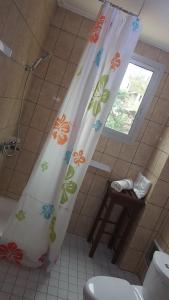 a bathroom with a shower curtain with flowers on it at Résidence hôtelière La Roseline in Yaoundé