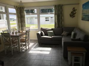 a living room with a couch and a table at Pine Song Chalet in Roch