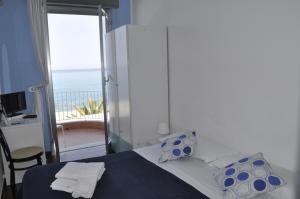 a bedroom with a bed with a view of the ocean at Hotel Ristorante La Scogliera - NUOVA GESTIONE in Piraino