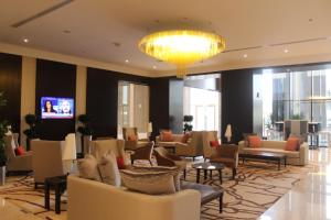 a lobby with couches and tables and a chandelier at Ascott Rafal Olaya Riyadh in Riyadh