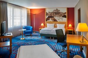 Habitación de hotel con cama y escritorio en Mercure Hotel Berlin Tempelhof en Berlín