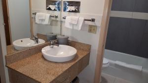 a bathroom with two sinks and a toilet and a mirror at Travelers Lodge Marshall in Marshall +40 photos