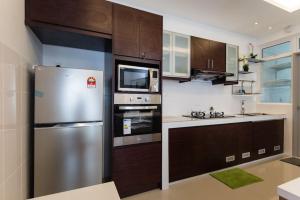 a kitchen with a stainless steel refrigerator and cabinets at Palm Armada Residence Free Parking and Netflix in Putrajaya