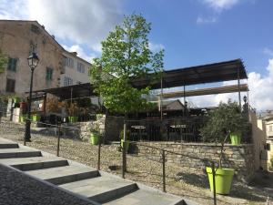 a restaurant with a fence and stairs and a tree at Hôtel U Passa Tempu in Corte