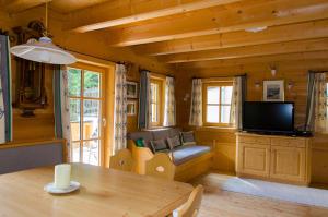 ein Wohnzimmer mit einem Tisch und einem TV in einer Hütte in der Unterkunft Family Lodge Maximilian in Tux