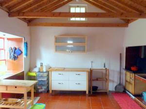 Habitación con cocina con mesa y escritorio. en Casa da Lagoa AL 416, en Fajã da Caldeira de Santo Cristo